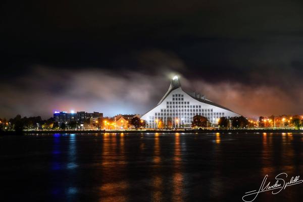 Die Nationalbibliothek in Riga türmt sich wie ein Berg mit leuchtender Spitze in den Nachthimmel